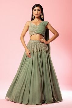 Sage green lehenga with attached cancan and cutdana, sequin, thread, bead embroidery in flower pattern. Paired with draped  padded blouse.
Components: 2
Pattern: Embroidery
Type Of Work: Cutdana, sequin, thread, bead, floral
Neckline: Sweetheart neck
Sleeve Type: Sleeveless
Fabric: Georgette
Color: Green
Other Details: 
Approx Weight: 3kg
Attached drape
Flared hem
Occasion: Destination Wedding - Aza Fashions Green Bridesmaid Lehenga, Sage Green Lengha, Sage Green Lehenga, Draped Lehenga, Off Shoulder Lehenga, Royal Blue Lehenga, Drape Lehenga, Rich Outfits, Green Drapes