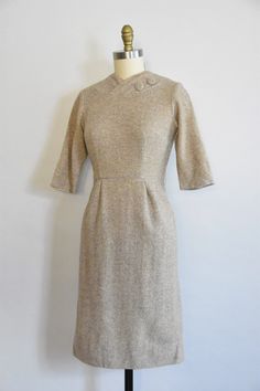 "Vintage 1950s wool dress. Oat colored wool. V high collar with decorative buttons, seamed bust, and long sleeves. Straight skirt with back metal zipper closure. Unlined. *item has not been dry cleaned State of garment | excellent. Measurements ✂--- Best fit | Small/ Medium Bust | up to 35\" Shoulders | 14\" Shoulder to waist | 15\"\" Sleeves | 15\" Waist | 26.5- snug 27\" Hips | up to 38\" Total length (shoulder to hem) | 39\" Tag | ★★Visit The Shop★★ http://www.etsy.com/shop/seaofvintage ➸ Fin Fitted Cream Tweed Dress For Fall, Beige Vintage Dress For Fall, Classic Beige Tweed Dress For Formal Occasions, Beige Long Sleeve Vintage Dress For Formal Occasions, Vintage Beige Dress For Winter, Vintage Beige Dresses For Winter, Beige Long Sleeve Tweed Dress For Formal Occasions, Beige Fitted Vintage Dress For Formal Occasions, Fitted Beige Tweed Dress For Winter