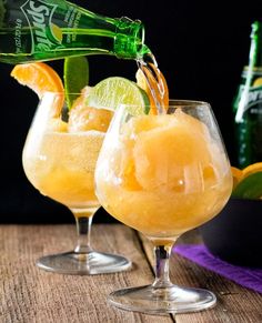 two glasses filled with drinks sitting on top of a table