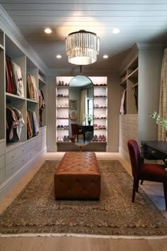 a living room filled with furniture and a chandelier hanging from the ceiling over a rug