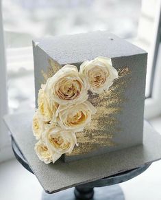 the cake is decorated with flowers and gold glitters on it's top tier