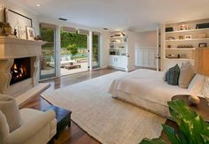 a large bedroom with a fireplace in the center and lots of shelves on either side