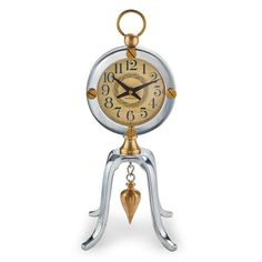 an antique style clock with a bell and pendulum on it's side, sitting on a white background