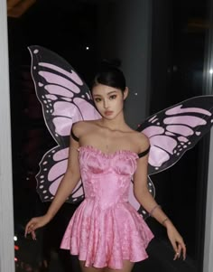 a woman in a pink dress and butterfly wings