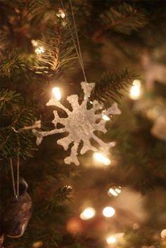 a snowflake ornament hanging from a christmas tree