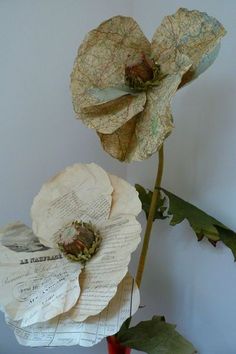 two paper flowers sitting on top of a table