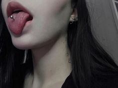 a woman with piercings sticking out her tongue