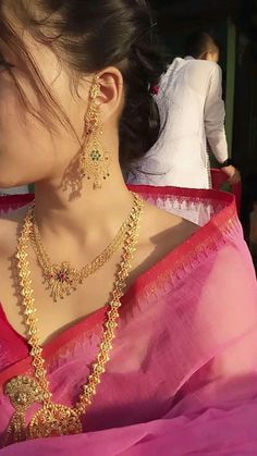 a woman in a pink saree with gold jewelry