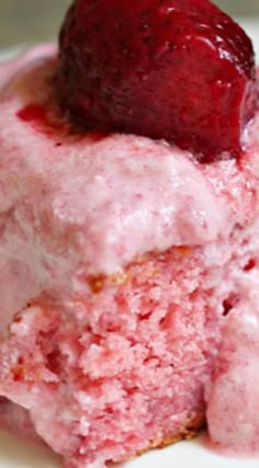 a close up of a piece of cake on a plate with a strawberry in it