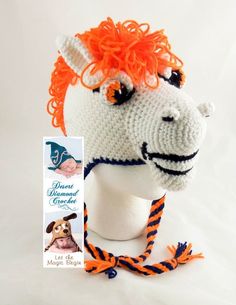 a crocheted hat with an orange and white horse's head