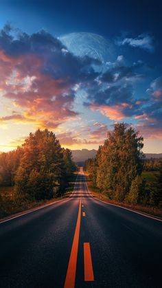 an empty road with trees on both sides and the sun setting in the distance behind it