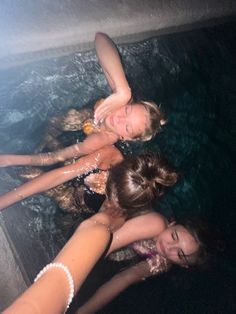 three girls are in the water with their arms around each other