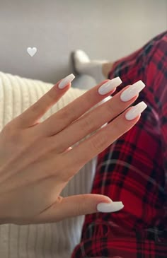 a woman's hands with white manies and a heart on the nail tip