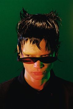 a man with black hair and sunglasses on his face