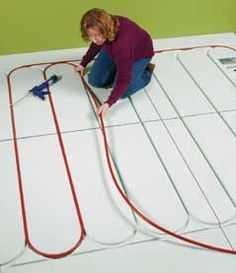 a woman is working on the floor with wires