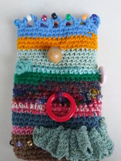 there is a cell phone case made out of crochet and yarn with buttons on it