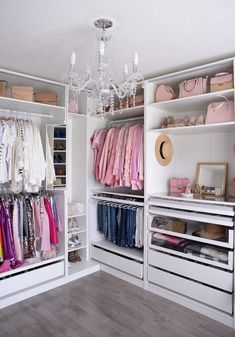 an organized closet with clothes and handbags on the shelves, chandelier hanging from the ceiling