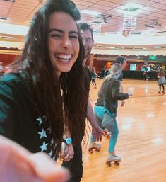 a group of people riding skateboards on top of a hard wood floored floor