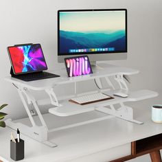 two laptops and a desktop computer sitting on a white desk with the same monitor