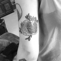 a black and white photo of a pomegranate tattoo