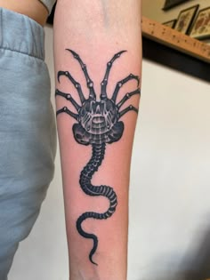 a black scorpion tattoo on the arm