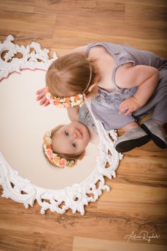 two babies are sitting on the floor looking at each other