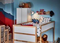 a child's bedroom with blue walls and wooden furniture