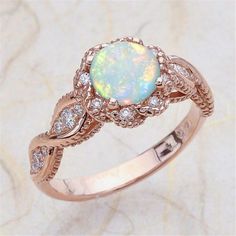 an opal and diamond ring on a marble surface