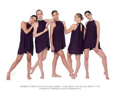 six women in purple dresses posing for the camera