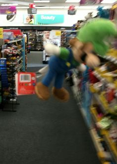 a stuffed animal hanging from the ceiling in a toy store with other toys on display