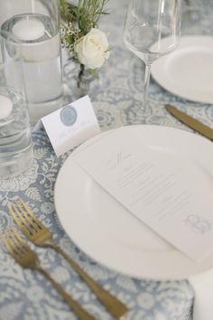 the table is set with silverware and place settings