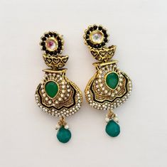 Intricately handmade antique drop earrings embellished with green onyx and pearl. The earrings are made in brass. Pushback closure. Vintage Green Jeweled Earrings, Elegant Green Chandelier Earrings With Intricate Design, Elegant Handmade Green Danglers, Vintage Green Brass Earrings, Green Pearl Drop Earrings For Festive Occasions, Green Drop Pearl Earrings For Festive Occasions, Elegant Green Chandelier Earrings With Latkans, Festive Green Pearl Drop Earrings, Elegant Green Danglers With Latkans