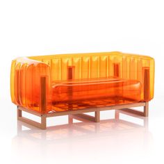 an orange couch sitting on top of a wooden stand