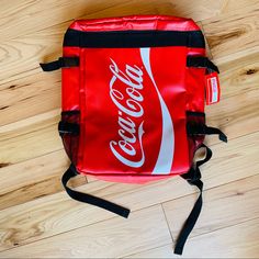 a coca cola bag sitting on top of a wooden floor