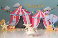 a circus themed birthday party with an elephant cake topper and tent decorations on the table