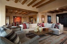 a living room filled with furniture and lots of wood beamed ceilinging on top of it