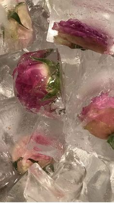 several pieces of food that have been placed on some ice with water and flowers in them