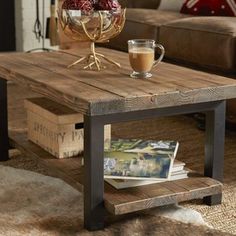 a coffee table with magazines on it and a glass of coffee next to it in front of a couch