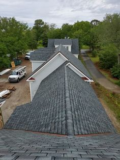 an aerial view of a house with two cars parked in the driveway