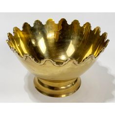 a brass bowl with scalloped edges on a white background