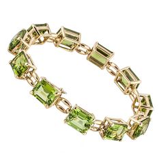 18K yellow gold line bracelet marked "18K Laura Munder" (on the clasp). Bracelet features 11 emerald-cut peridot stones with a total weight of 38 carats. Bracelet measures 7 inches long and 3/8 inches wide. Luxury Elegant Peridot Bracelets, Luxury Green Jubilee Gold Bracelet, Elegant Luxury Peridot Bracelets, Luxury Classic Peridot Jewelry, Luxury Yellow Gold Emerald Bracelet, Ethereal Jewelry, Eleven 11, Gold Tennis Bracelet, Tiaras Jewellery