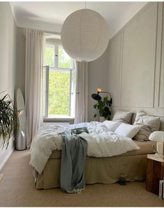 a bedroom with a large bed and white curtains