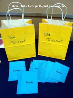 three yellow bags with blue paper on them and the words new testament written on them