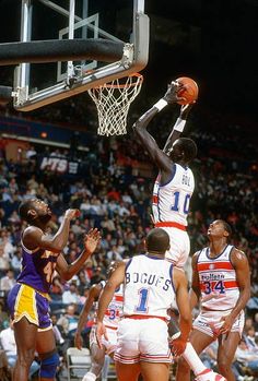 the basketball player is trying to dunk the ball in front of the other players