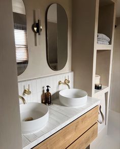 two sinks in a bathroom with mirrors above them