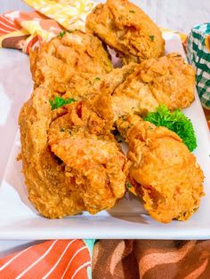 fried food on a white plate with green garnishes and napkins in the background