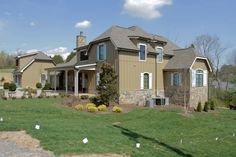 a large house sitting on top of a lush green field