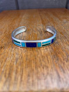 Beautiful Sterling Silver Turquoise and Lapis lazuli Inlaid Cuff Bracelet measuring approx 6 3/4" interior circumference including the gap of 1 3/8" and 3/8" wide, marked CCO925 Southwestern Blue Cuff Bracelet As Gift, Adjustable Southwestern Blue Cuff Bracelet, Southwestern Style Blue Bangle Bracelets, Southwestern Style Blue Bangle Bracelet, Bohemian Blue Bracelets With Inlay, Adjustable Blue Cuff Bracelet With Inlay, Adjustable Blue Inlay Cuff Bracelet, Southwestern Style Blue Inlay Bracelets, Adjustable Turquoise Bracelet With Inlay