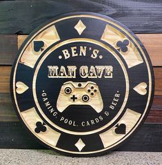 a wooden sign that says ben's man cave with a video game controller on it