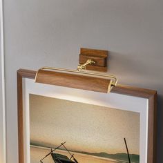 there is a framed photo with a boat on it and a light in the corner